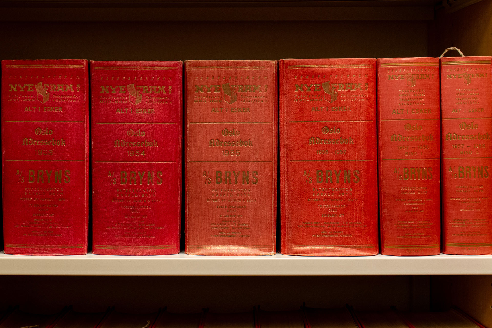 Nærbilde av ryggen på flere røde bøker.