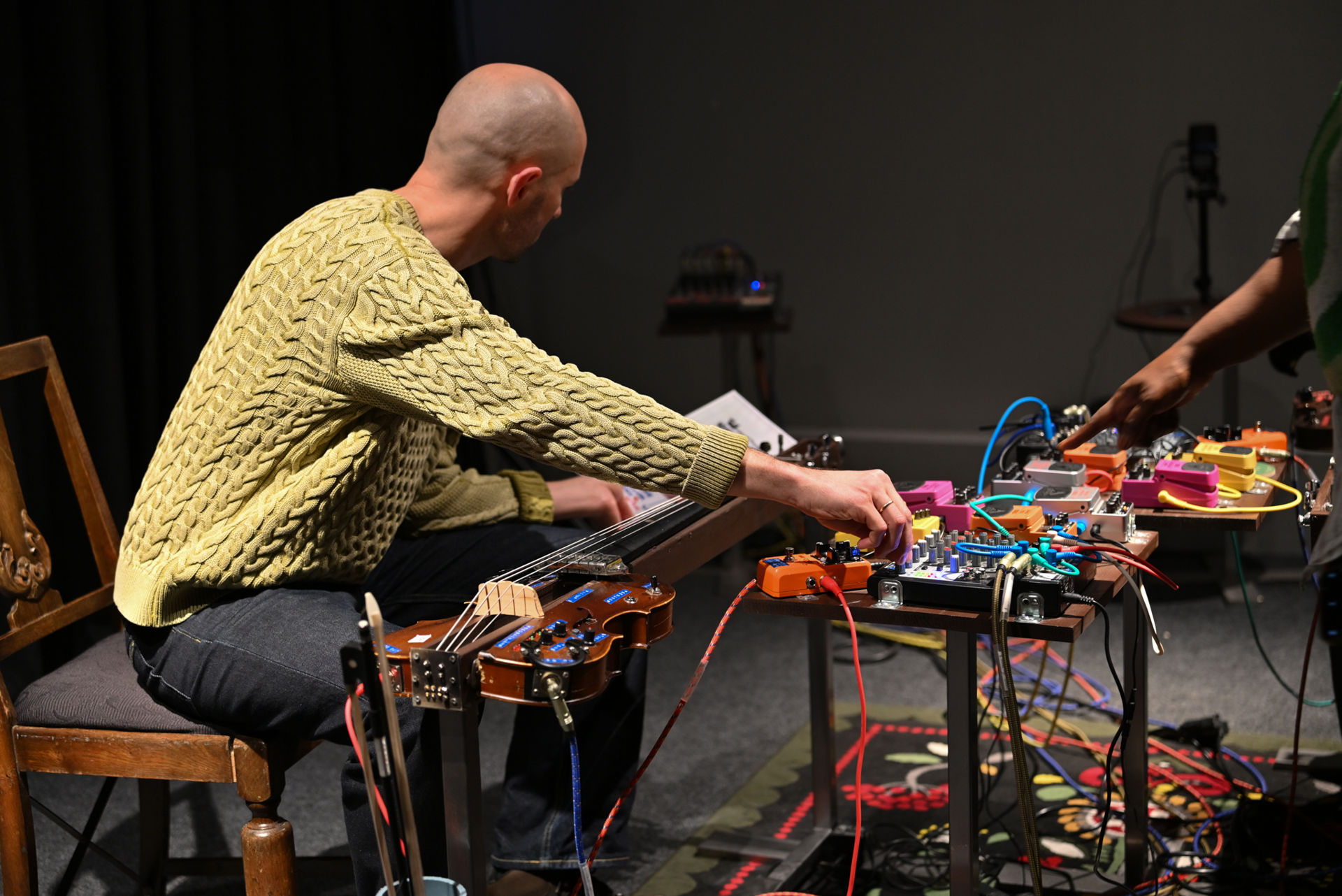 Mann spiller på et nyskapt instrument bestående av ulike deler og elementer
